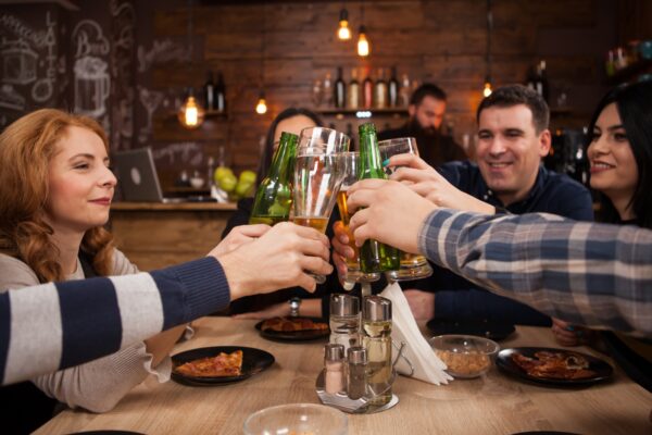 友人たちとビールを飲み、乾杯する・バー