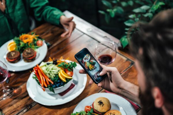 レストランで食べ物を撮る男性