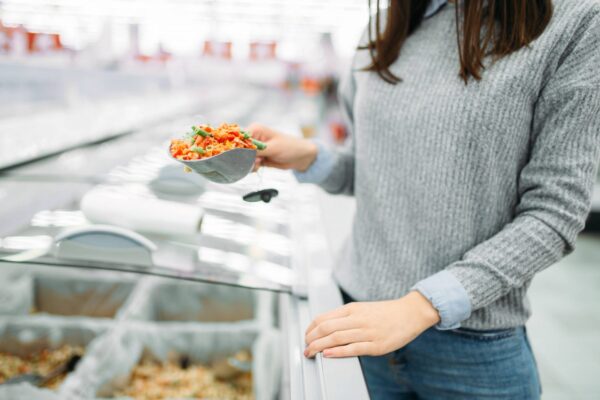 冷凍野菜のパックを手に取る女性