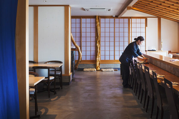 寿司屋でカウンターをセットするスタッフ