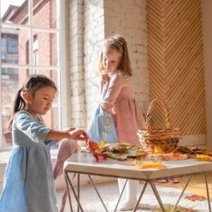 葉っぱで遊んでいる少女二人・子供服ブランド