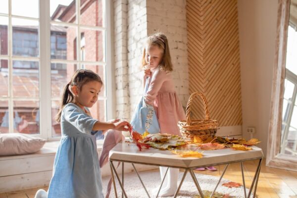 葉っぱで遊んでいる少女二人・子供服ブランド