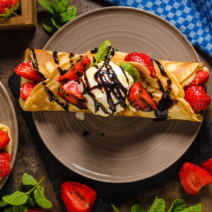 チョコレートソースといイチゴとホイップクリームが乗ったクレープ