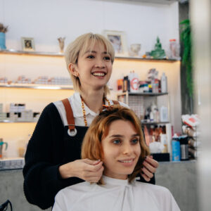 女性の美容師と客がヘアサロンでサービスを受けている写真