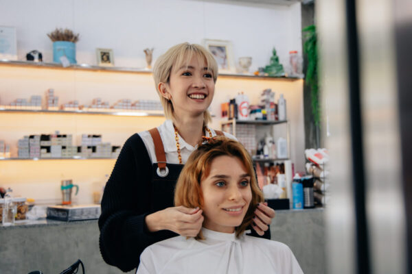 女性の美容師と客がヘアサロンでサービスを受けている写真